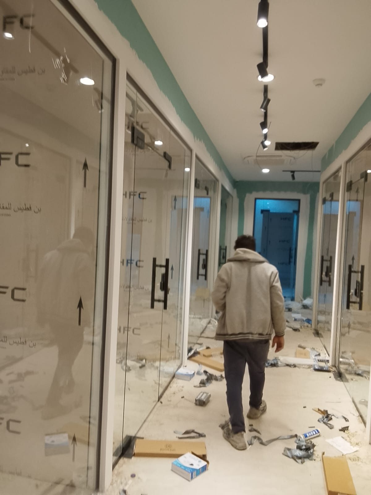 قواطع وأبواب زجاجية لمحلات على جانبي ممر داخلي